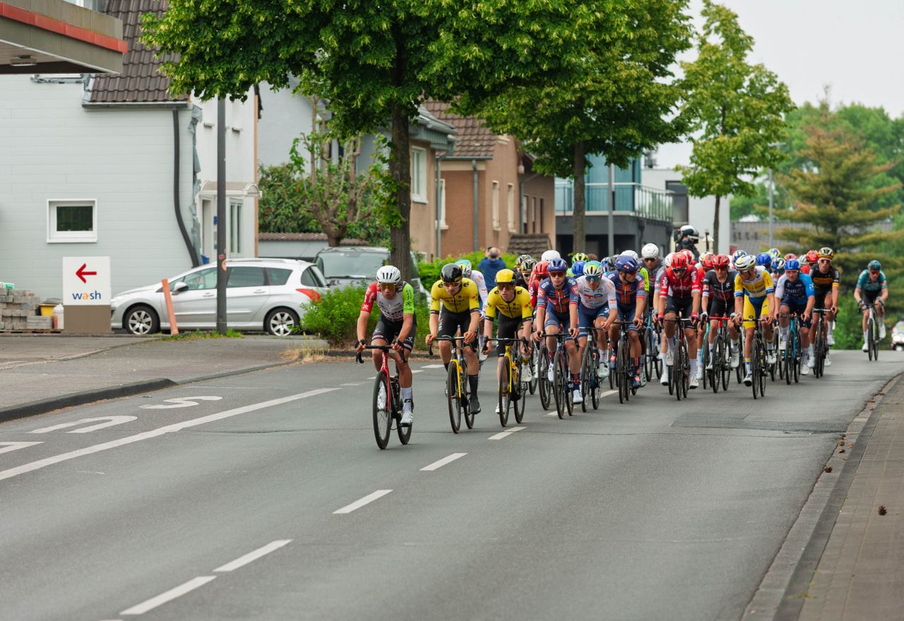 Cyclists in a high-speed competition racing through an urban area, showcasing athletic endurance and team strategies.